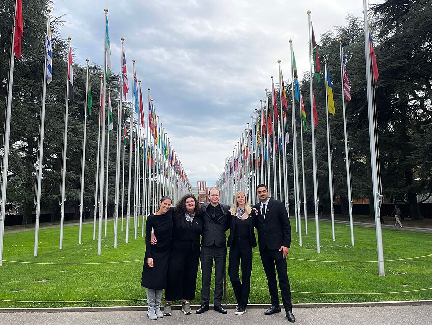 The five students posing next to the national flags at the United nation in Geneva