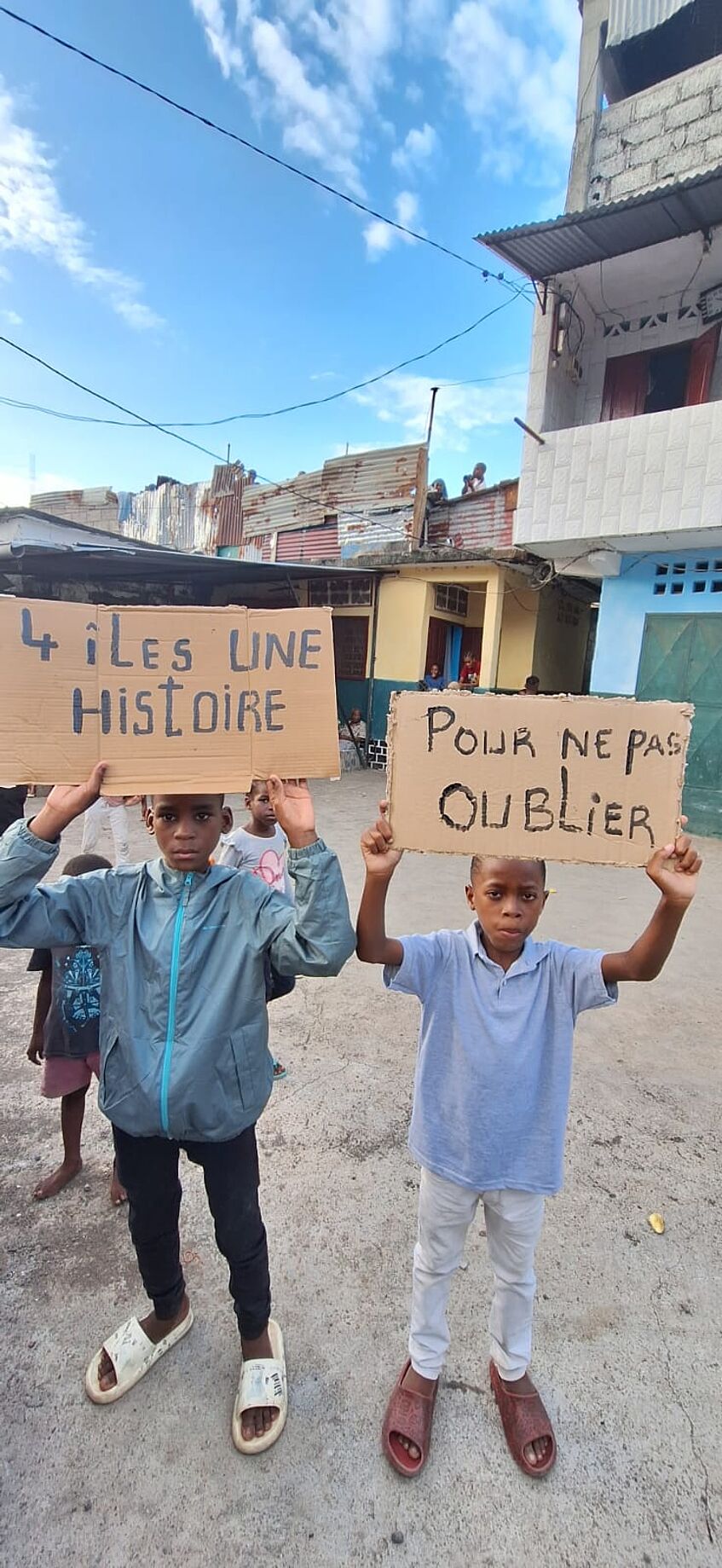 Zwei komorische Kinder halten Plakate 