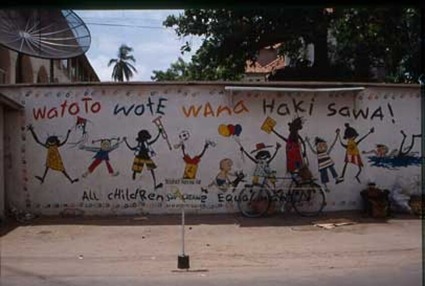Auf der Wand sieht man bunte Bilder, in Farbe gezeichnet, spielende Kinder, Mädchen und Buben, eines hat eine Trompete in der Hand, andere halten sich an den Händen. Und darüber steht in Swahili: Watoto wote wana haki sawa.